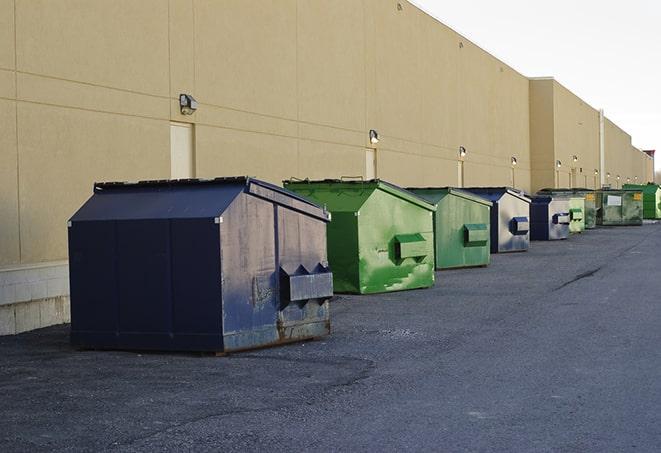 a pile of demolition waste sits beside a dumpster in a parking lot in Chelan